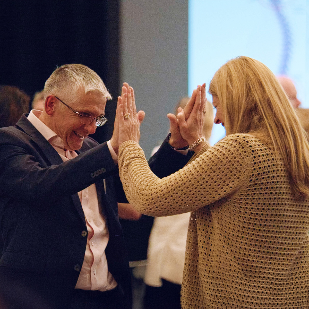 Two participants high-fiving during a Body & Brain session